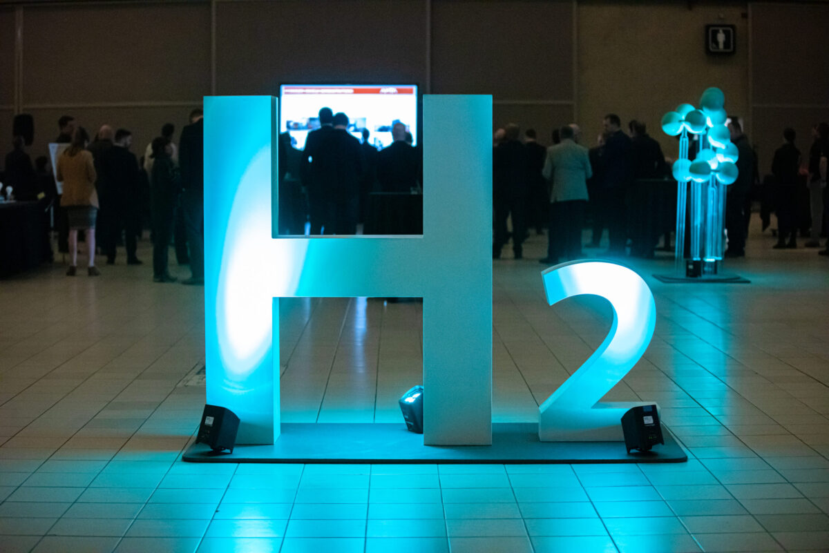 An "H2" sculpture at the Edmonton Convention Centre as a crowd mills in the background