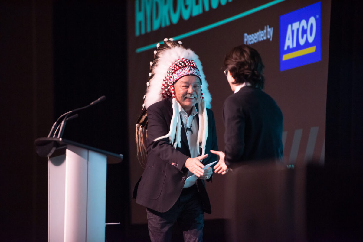 Event emcee Hunter Cardinal greets opening speaker Chief George Arcand at the 2023 Hydrogen Summit